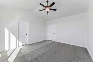 Unfurnished room with carpet floors, lofted ceiling, and ceiling fan