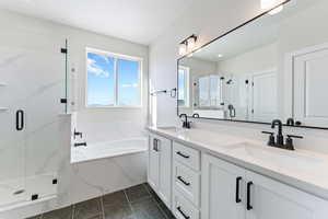 Bathroom featuring plus walk in shower, tile patterned floors, and vanity