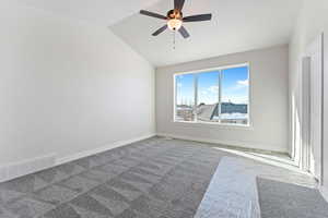 Spare room with ceiling fan, carpet, and lofted ceiling