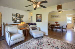 Sitting room featuring ceiling fan and dark wood-type flooring