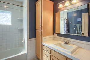 Bathroom with vanity, tile walls, and shower / bath combo