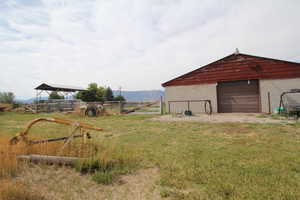 View of yard featuring a mountain view, a rural view, and an outbuilding