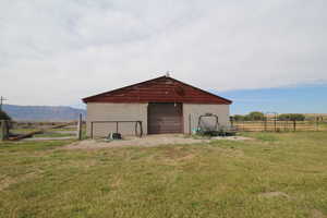 View of outdoor structure with a lawn, a rural view, and a mountain view