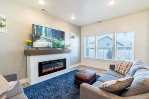 Living room showcases a custom electric fireplace! Make sure you pull down the mantle the showcase hidden storage, and the side panels revealing hidden shelves!