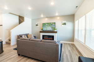 Living room featuring light hardwood / wood-style flooring. Check out the hidden storage in the fireplace!