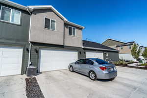 View of property featuring a garage and central air condition unit