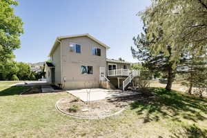 Back of house with a patio and a yard