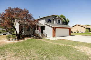 View of front property featuring a garage and a front lawn