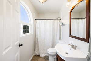 Primary Bathroom featuring curtained shower, vanity, toilet, and tile patterned floors