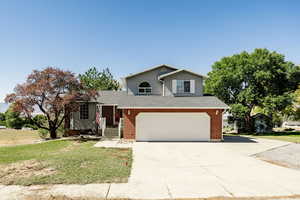 View of front of home featuring a front lawn and a garage