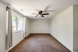 Empty room featuring carpet floors and ceiling fan