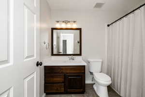 Bathroom featuring vanity, toilet, and tile patterned floors