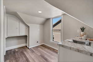 Upstairs Mother-In-Law kitchenette with LVP flooring, storage cabinets and range hookup.