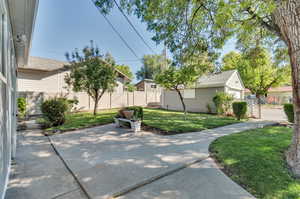 View of patio and private drive with garage and additional parking.