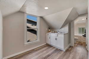 Upstairs Mother-In-Law kitchenette with LVP flooring, white cabinetry, and sink.