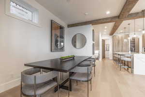 Dining space featuring beamed ceiling and light wood-type flooring