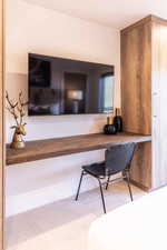 Office area featuring light colored carpet and built in desk