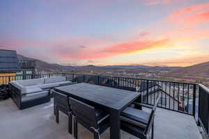 Patio terrace at dusk with a mountain view and an outdoor living space