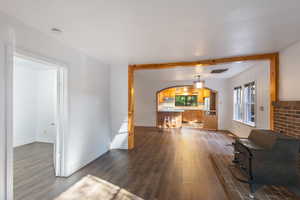 Living room with LVP / wood-style floors and beam ceiling (main level bedroom to the left in this photo)