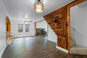 Unfurnished living room featuring LVP / wood-style floors, wood walls, and a wood stove