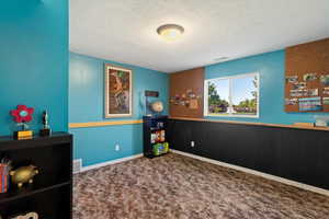 Carpeted bedroom with a textured ceiling