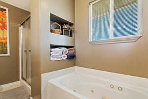 Bathroom featuring shower with separate bathtub and a textured ceiling