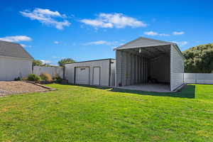 View of yard with an outbuilding, a carport, and a garage