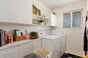 Laundry room featuring cabinets and washer and dryer