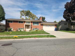 View of front of property featuring a garage and a front lawn