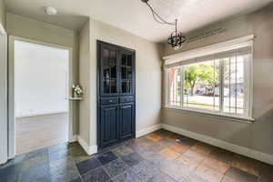 Interior space featuring an inviting chandelier, a textured ceiling, and dark hardwood / wood-style floors