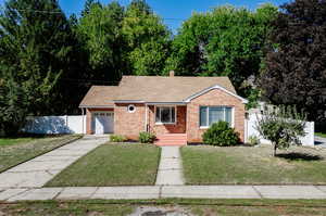 View of front of home featuring a front yard and a garage