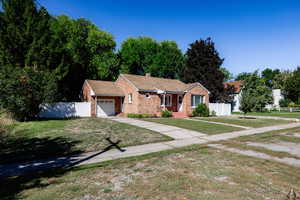 View of front of home with a garage and a front lawn