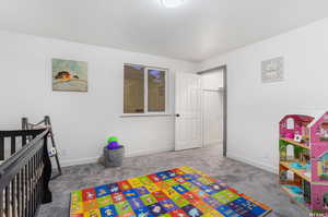 Bedroom featuring a crib and carpet flooring