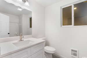 Bathroom with heating unit, vanity, and toilet