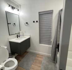 Bathroom featuring hardwood / wood-style flooring, vanity, and toilet