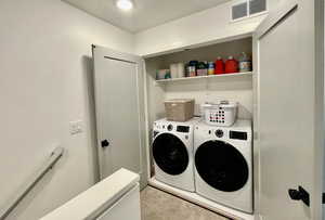 Clothes washing area featuring washing machine and dryer