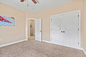 Unfurnished bedroom with a closet, ceiling fan, and carpet floors