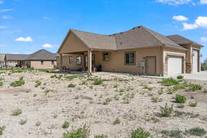 Rear view of house featuring a garage and a patio