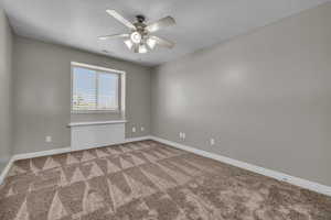 Carpeted spare room with ceiling fan and a textured ceiling