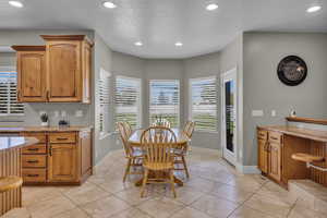 Interior space with light stone counters, light tile patterned flooring, and a textured ceiling