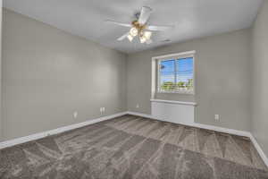 Carpeted empty room featuring ceiling fan