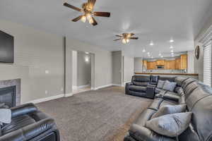 Carpeted living room with ceiling fan