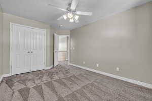 bedroom with a closet, ceiling fan, and light colored carpet