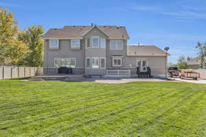 Rear view of house with a yard and a patio