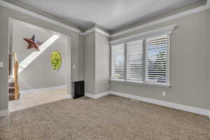 Carpeted spare room with ornamental molding