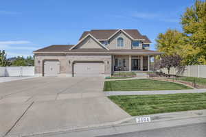 View of front of house with a front yard, a garage, and a porch