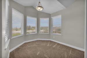 Spare room with carpet and lofted ceiling