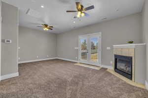 room featuring ceiling fan, light colored carpet, a textured ceiling, and a fireplace