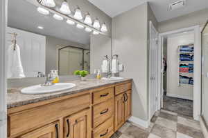 Bathroom with a shower with door and vanity