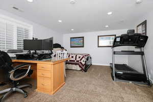 Home office featuring carpet floors and a textured ceiling